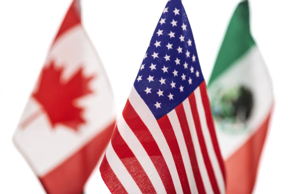 close up of the american flag with the canadian and mexican flags behind it on a white background concept negotiations